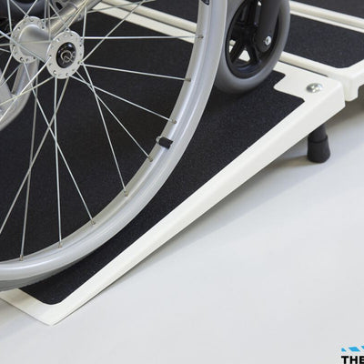 the image shows a close up of a wheelchair using the fibreglass folding threshold ramp