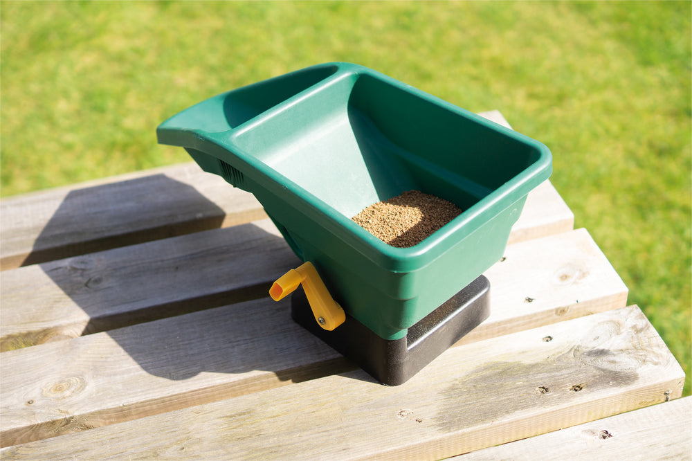 Home and Garden Manual Seed Spreader in use, full of seed.