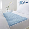 The image shows the pale blue Kylie Bed Pad in place on a bed