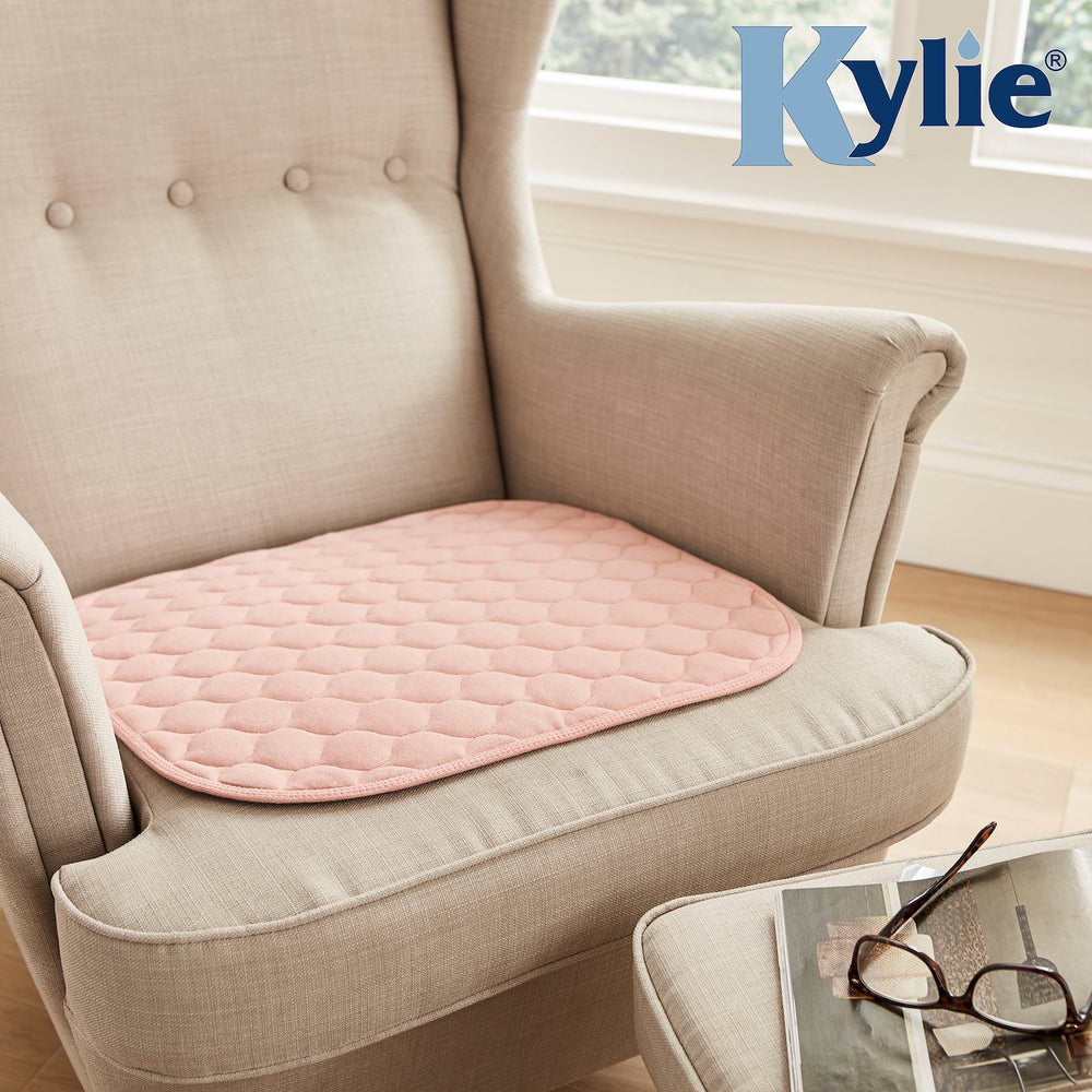 A mobility aid of the pink Kylie Chair Pad in place on an armchair