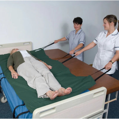Two nurses using the Transfer Glide Sheet to help transfer a patient