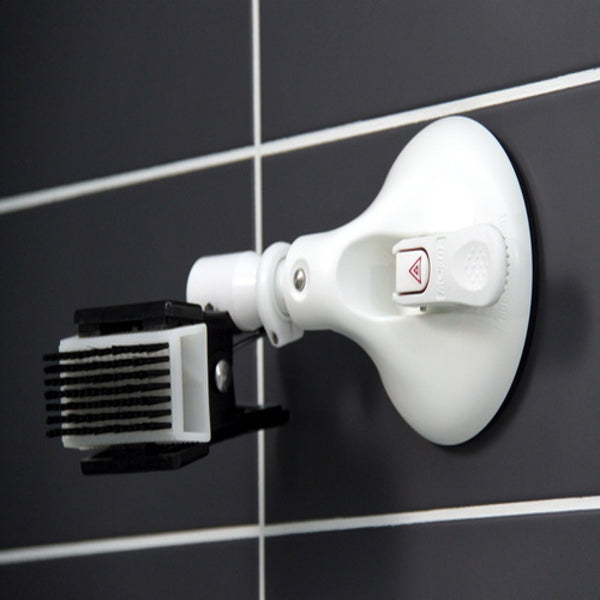 shows Mobeli Clip Holder without swivel arm, fitted to a grey tiled wall and holding a nail brush,