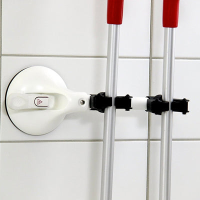 the image shows the mobeli dual cane holder attached to a tiled surface holding two walking sticks in place