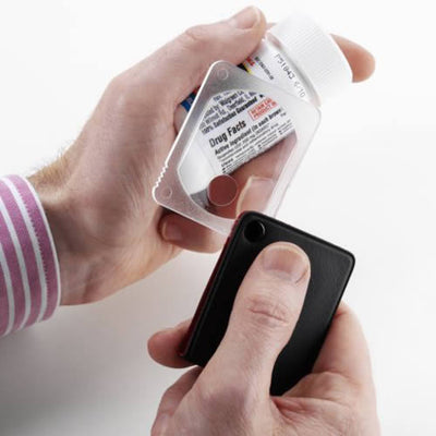 The Flip Out Pocket Magnifier being used to look at a jar of pills