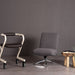 The image shows the Page Indoor Rollator with dark brown leatherette seat, alongside a chair and small coffee table