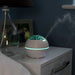 the image shows the Lifemax projection humidifier on a bedside table with both mist and light