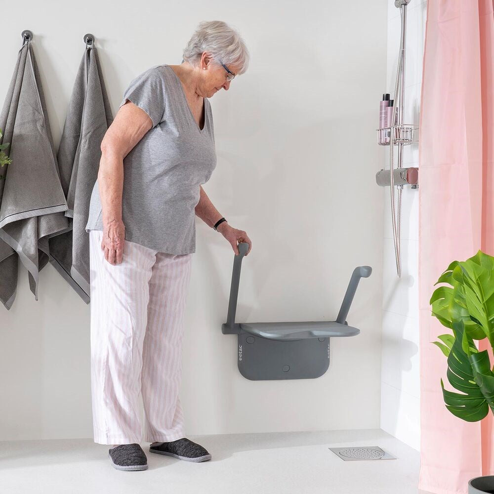 Lady looking at Shower seat, she is touching the arm