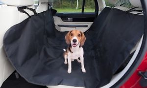 shows a small dog seated in the rear of a car on the Crufts Car Hammock