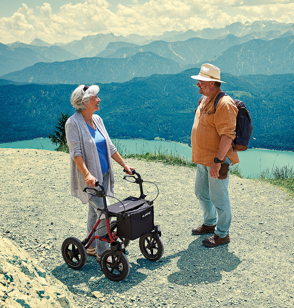 shows a woman chatting to man with a Dietz Taima Rollator XC on a scenic walk