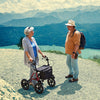 shows a woman chatting to man with a Dietz Taima Rollator XC on a scenic walk
