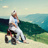shows a woman resting on a Dietz Taima Rollator in a picturesque setting