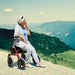 shows a woman resting on a Dietz Taima Rollator in a picturesque setting