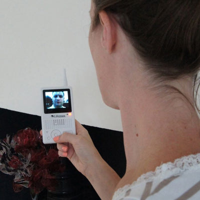 the image shows a young woman using the lifemax wireless video door phone
