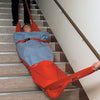 Two medical employees using the Evacuation Sledge to move someone on some stairs